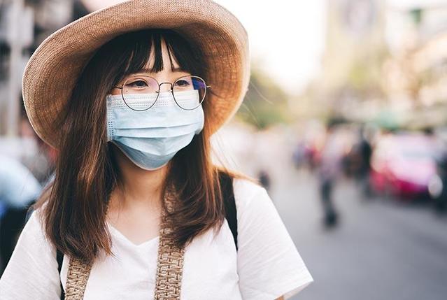 Asian woman wearing glasses with a mask on